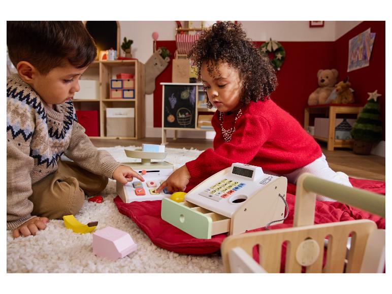 Twee kinderen spelen winkeltje met de houten speelgoedkassa